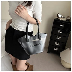 Detail of silver matte jelly tote bag with black round handles and stylish logo