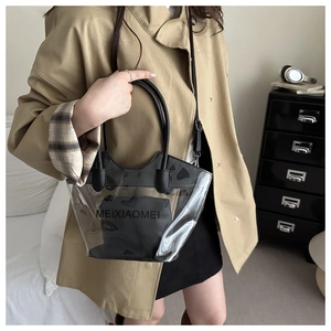 Détail du sac cabas en PVC transparent avec pochette noire et poignées rondes sur modèle
