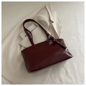 Détails du sac bandoulière en cuir ciré bordeaux avec boucles argentées et finitions chic