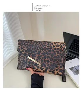 Détail de la pochette léopard avec fermeture en métal doré et dragonne de poignet