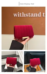 Dettaglio borsa in velluto rosso con cuciture verticali e chiusura in metallo dorato