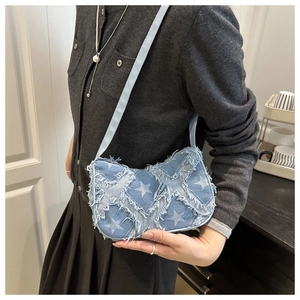 Détail du sac bandoulière en denim avec motifs d'étoiles effilochés et fine chaîne
