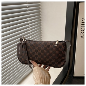 Detail view of vintage brown shoulder bag with monogram M print and stylish hanging tag