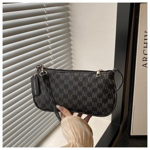 Close-up of retro underarm bag featuring letter pattern jacquard and fashion brand tag