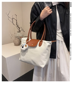 Détail du cabas en nylon blanc avec rabat en cuir et porte-clé chien en peluche mignon
