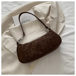 Close-up of leopard print underarm bag with matte texture on a beige blazer