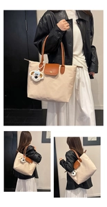 Détail du sac cabas en nylon beige avec rabat en cuir brun et breloque chiot en peluche