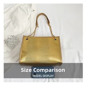 Comparaison de taille d'un sac cabas doré aspect crocodile avec une chaîne et un mobile