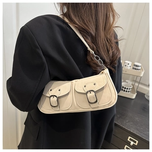 Detail view of retro beige baguette bag with double front pockets and chain shoulder strap