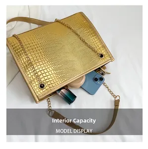 Détail de la capacité interne du sac cabas doré avec chaîne et gaufrage crocodile