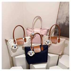 Vue détaillée de sacs cabas en nylon colorés avec pendentifs chiots en peluche