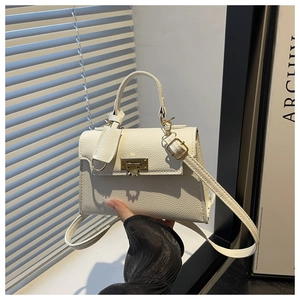 Close-up of white litchi pattern faux leather square bag with gold metal buckle
