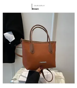 Detailed view of a brown pebbled faux leather bucket bag with a metal fashion logo
