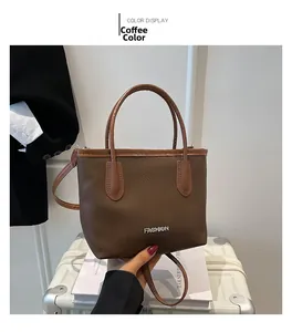 Detail of coffee brown pebble leather bucket bag with fashion metallic logo and handle