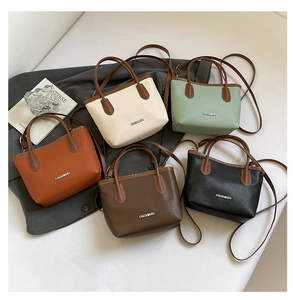 Flat lay of small bucket bags in five colors with contrast handles and logo detail