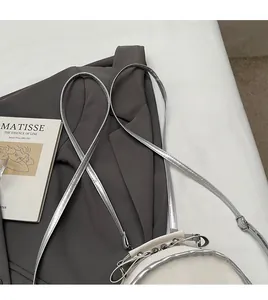 Adjustable silver shoulder strap and metal chain detail on white minimalist crossbody bag