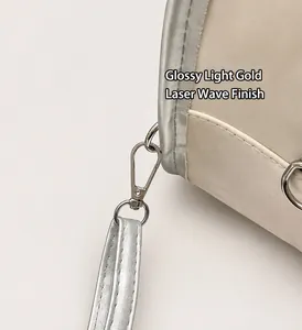Detail of silver lobster clasp and leather strap on a stylish cream-colored backpack