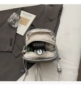 Top view of metallic silver mini backpack interior showing large capacity and storage