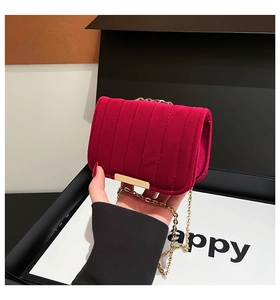 Detailed close-up of quilted burgundy velvet bag with gold hardware and chain
