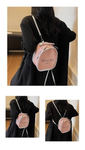 Detail of pink fashion backpack with silver metallic straps and black letter print