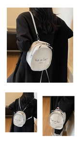 Detailed close-up showing the sleek white leather texture and black letter printing on backpack