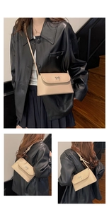 Détail du sac bandoulière beige clair avec boucle argentée et nœud sur la lanière