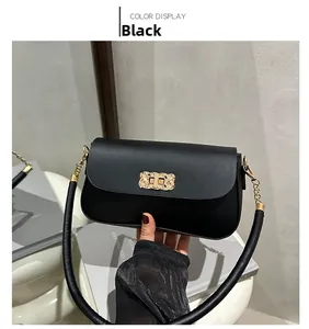 Detail of minimalist black crossbody bag with gold woven buckle and thick round strap