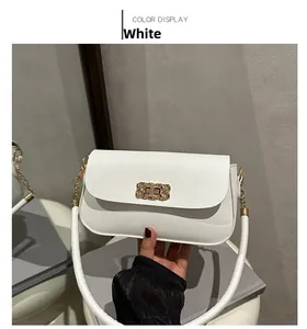 Detailed close-up of white crossbody bag featuring elegant gold woven texture metal twist lock