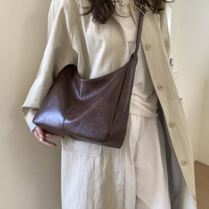 Dettaglio borsa tote in morbida pelle marrone con texture vintage e tracolla regolabile