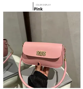 Detail of pink crossbody bag with a gold rectangular woven buckle and smooth leather finish