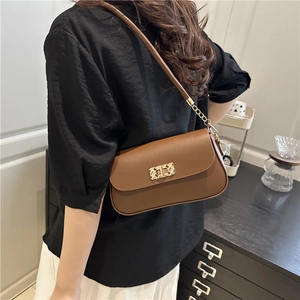 Sac bandoulière chic en cuir marron avec boucle dorée et bandoulière chaîne sur modèle