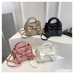 Bow-knot bucket bags in beige, black, pink and white with round handles and straps