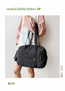 Detail of black tote bag featuring signature heart quilting and functional front zipper