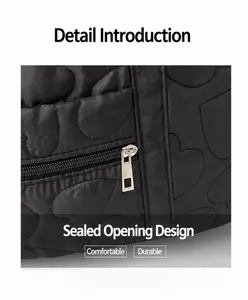 Detail of heart-shaped quilted black fabric and smooth silver metal zipper closure