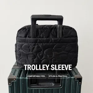 Detail showing the back trolley sleeve of the black heart quilted travel tote bag