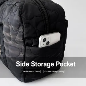 Close-up of black quilted bag side pocket featuring a heart pattern and phone storage