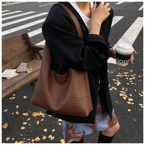 Deep brown woven tote bag detail showing autumn urban street style with crossbody strap