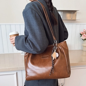 Brown vintage faux leather tote bag with fashion label and baseball glove keychain