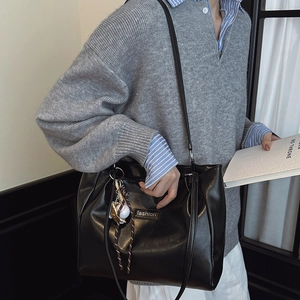 Minimalist black leather tote bag for women with baseball charm and chain detail