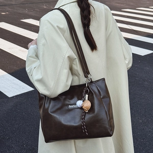 Retro coffee brown large tote bag in matte leather worn with a beige trench coat