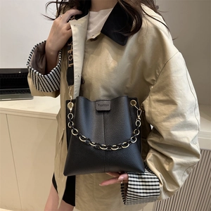Fashionable black lychee leather bucket bag with gold chain and lettered strap