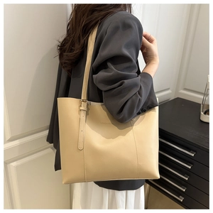 Detail of beige tote bag showing slim adjustable shoulder strap and FASHION & BAGS logo