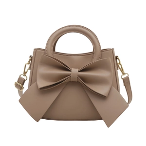 Minimalist khaki shoulder bag with bow detail and gold hardware on white background
