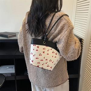 Contrast white shoulder bag with red cherry print and adjustable black knotted strap