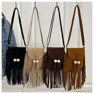 Detail view of four bohemian faux suede tassel crossbody bags with wooden beads