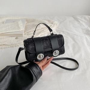 Mini black handbag with white floral patterns and metal twist locks on white background