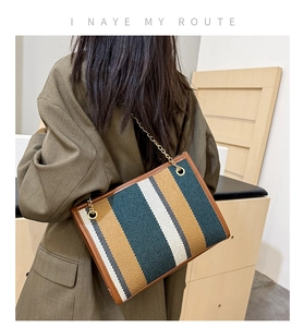 Detail of vintage striped tote bag with gold chain strap and high-quality canvas texture