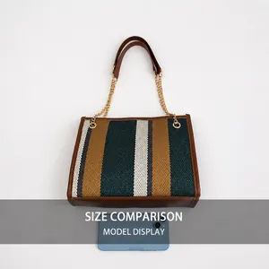 Detailed comparison of striped tote bag size next to a smartphone for scale