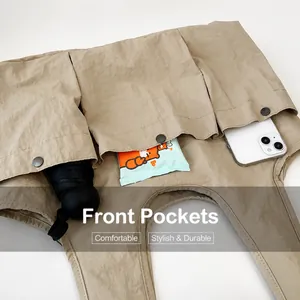 Detail of multi-pocket tote bag showing front compartments for phone and daily items