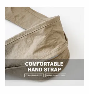 Detail of khaki tote bag handle with double-row stitching and crinkled nylon texture
